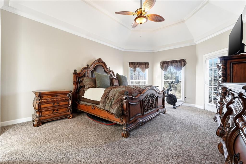 585 Tilbury Drive Suwanee, GA 30024 - Photo 19 of 46 a bedroom with a bed a flat screen tv and a chandelier