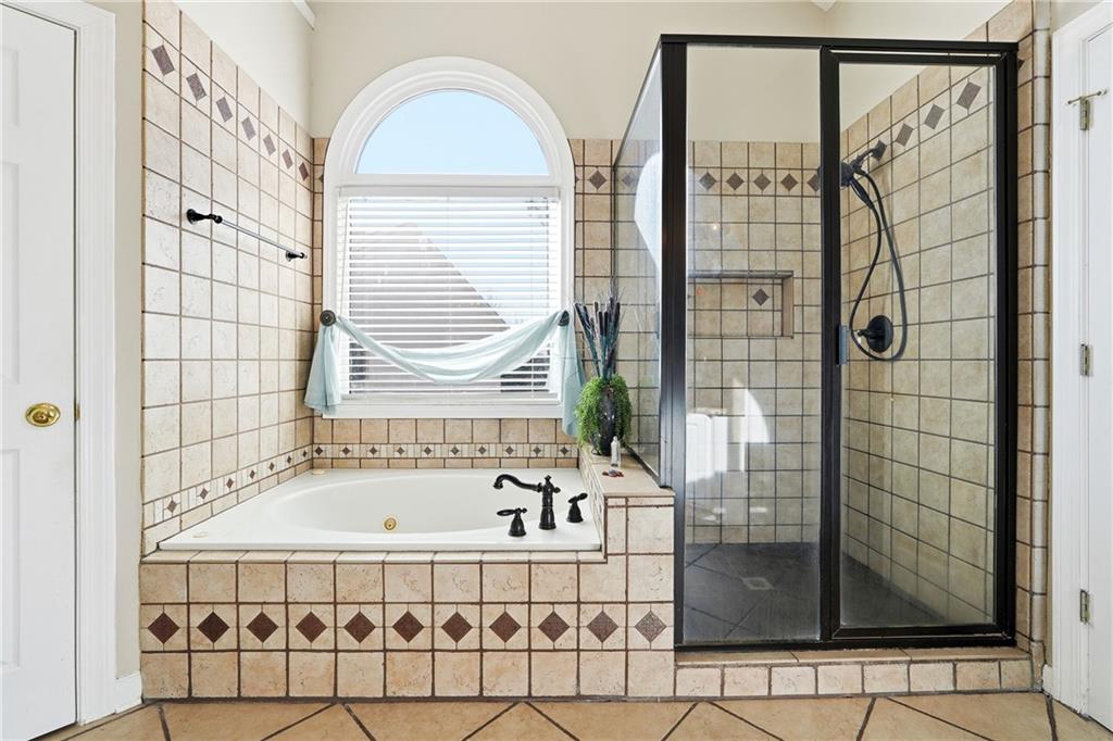 585 Tilbury Drive Suwanee, GA 30024 - Photo 21 of 46 a bathroom with a bathtub and shower