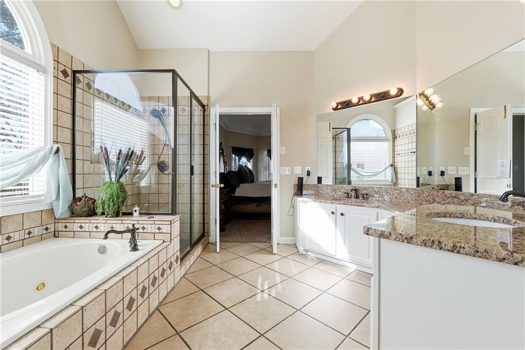 585 Tilbury Drive Suwanee, GA 30024 - Photo 22 of 46 a large bathroom with a granite countertop sink mirror and a bath tub