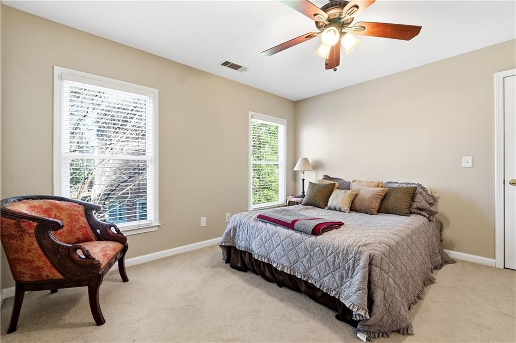 585 Tilbury Drive Suwanee, GA 30024 - Photo 23 of 46 a bedroom with a bed and a chandelier