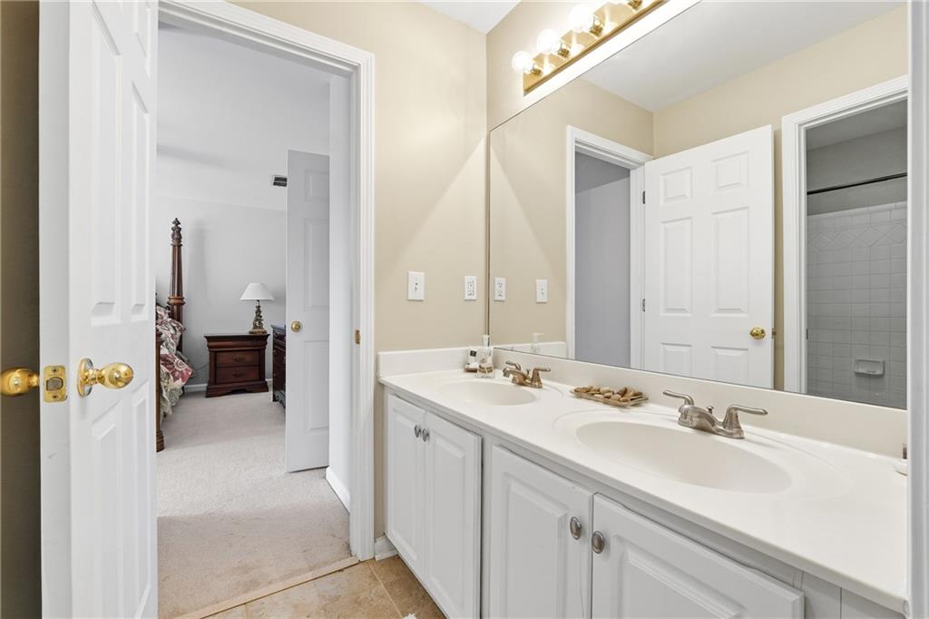 585 Tilbury Drive Suwanee, GA 30024 - Photo 25 of 46 a en suite bathroom with a double vanity sink