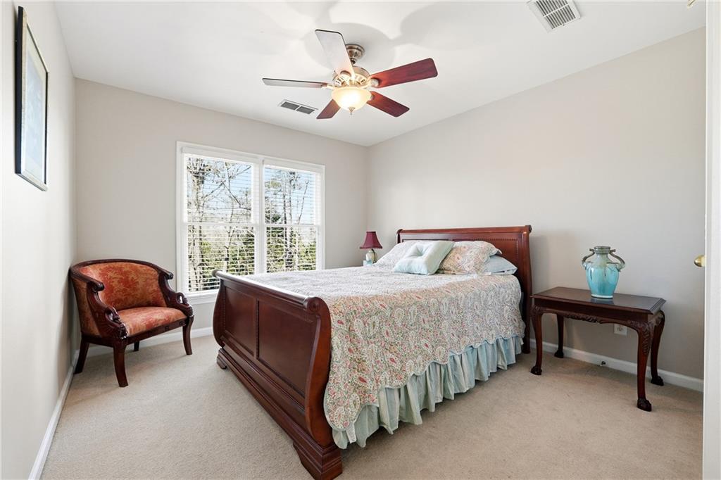 585 Tilbury Drive Suwanee, GA 30024 - Photo 27 of 46 a spacious bedroom with a bed and a chandelier