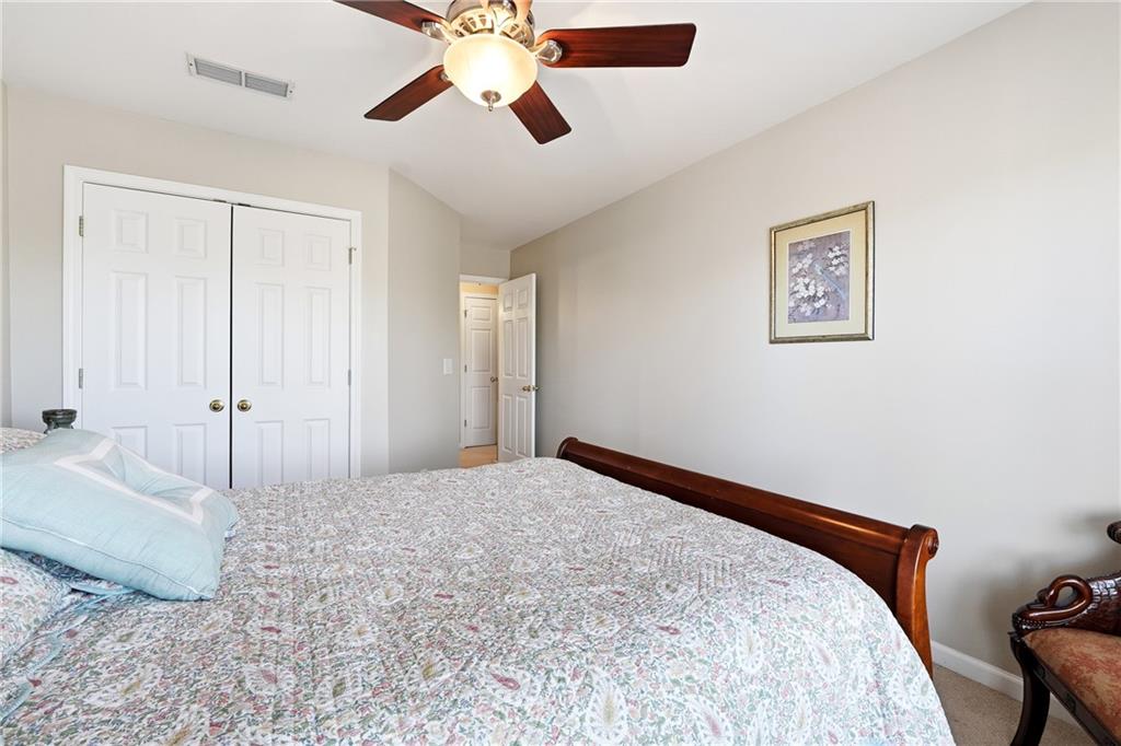 585 Tilbury Drive Suwanee, GA 30024 - Photo 28 of 46 a view of a bedroom with a bed and a chandelier fan