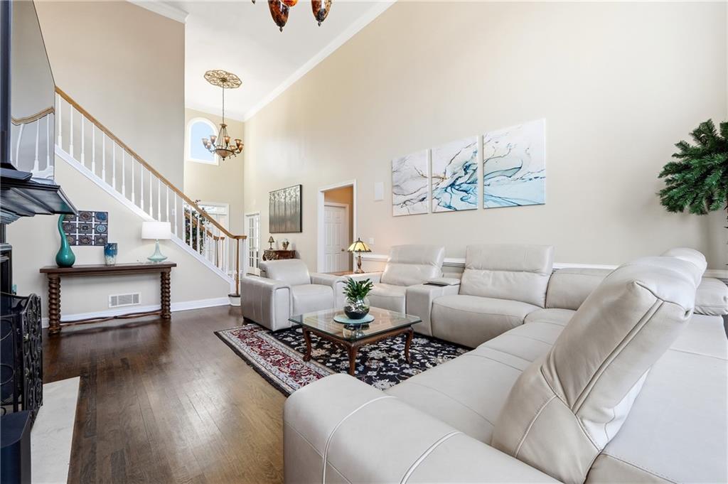 585 Tilbury Drive Suwanee, GA 30024 - Photo 8 of 46 a living room with furniture and a dining table with wooden floor