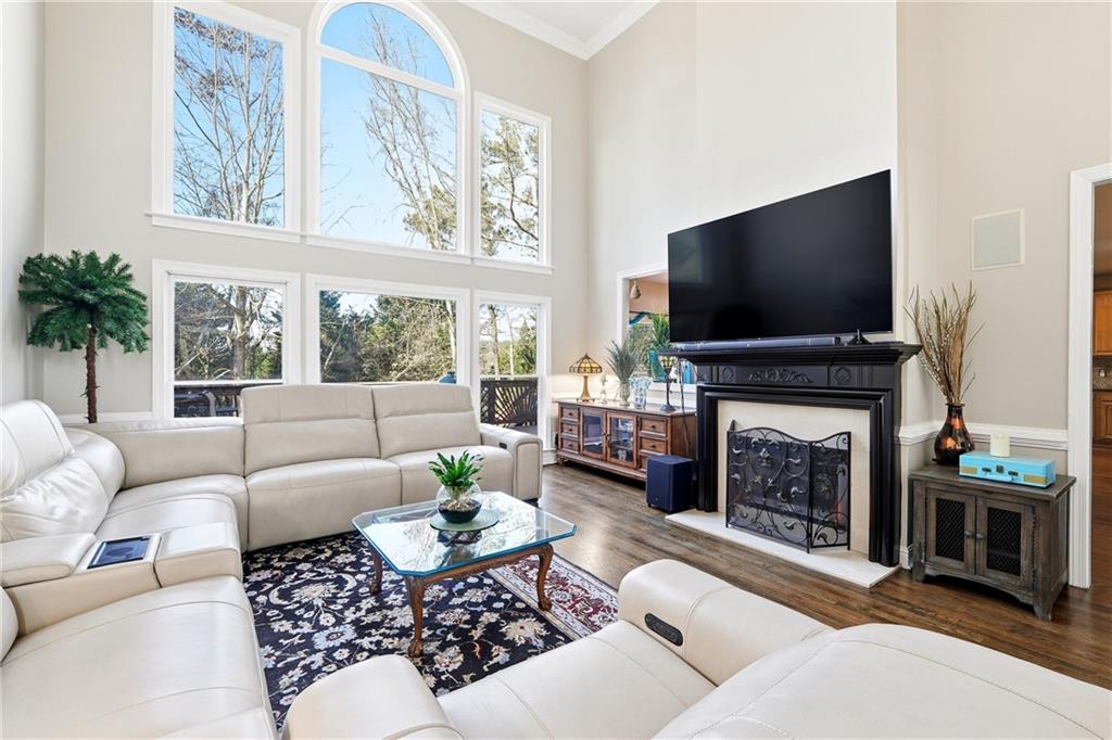 585 Tilbury Drive Suwanee, GA 30024 - Photo 10 of 46 a living room with furniture a flat screen tv and a fireplace