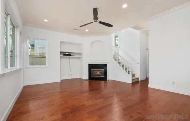 an empty room with windows and fireplace