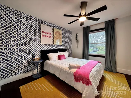 a bedroom with a bed and a lamp on dresser