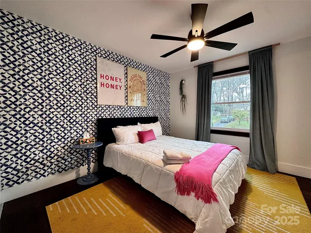 a bedroom with a bed and a lamp on dresser