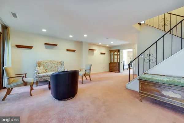 a living room with couches and a dining table with wooden floor