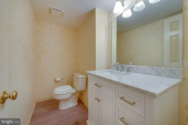 a bathroom with a granite countertop sink a toilet and a mirror