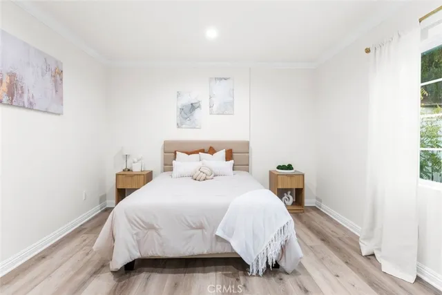 a bedroom with a bed and wooden floor