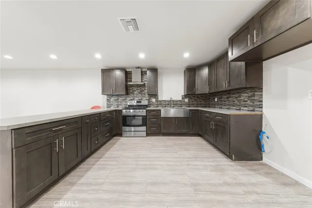 a kitchen with stainless steel appliances kitchen island granite countertop a refrigerator and a stove top oven