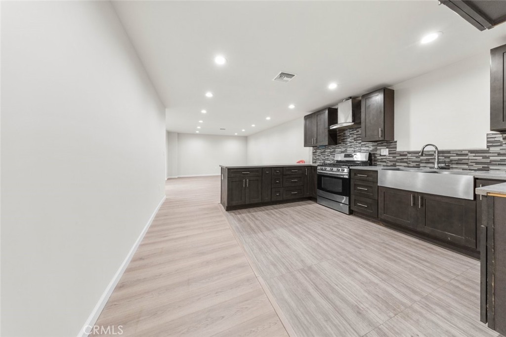10554 Plainview Avenue Tujunga, CA 91042 - Photo 34 of 56 a large white kitchen with stainless steel appliances granite countertop a stove and a wooden floors