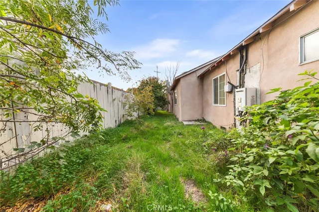 a front view of a house with garden and trees
