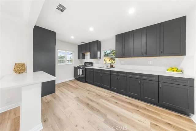 a kitchen with a sink cabinets and wooden floor