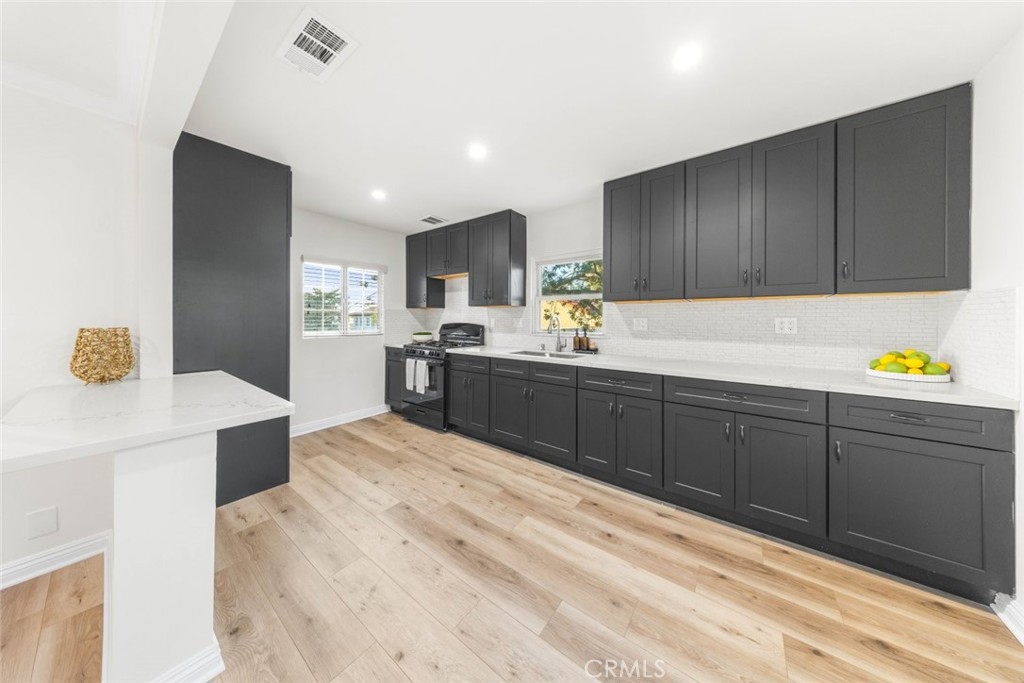 10554 Plainview Avenue Tujunga, CA 91042 - Photo 8 of 56 a kitchen with a sink cabinets and wooden floor