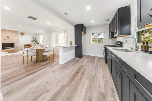 a large kitchen with stainless steel appliances lots of counter space and wooden floor