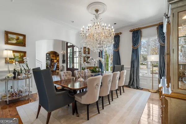 a living room with furniture a fireplace and a chandelier
