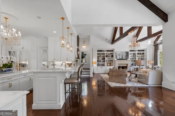 a dining room with furniture a chandelier and wooden floor