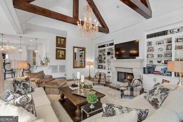 a living room with furniture a chandelier and a dining table