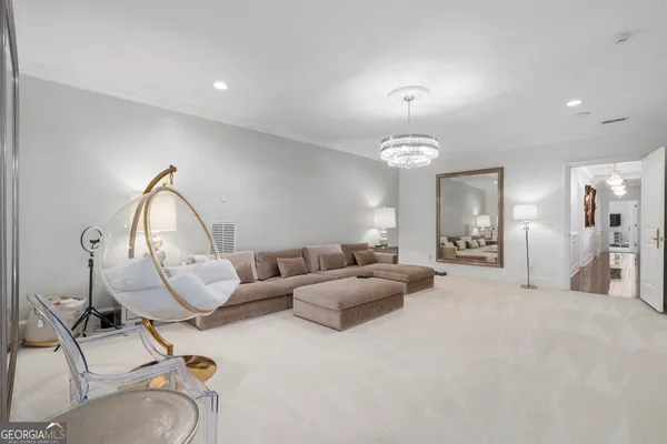 a view of a dining room and livingroom with furniture wooden floor a chandelier