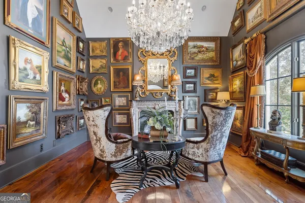 a view of a dining room with furniture a chandelier and wooden floor