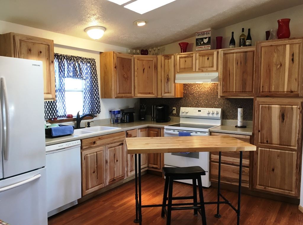 3708 2000 Road Delta, CO 81416 - Photo 12 of 42 a kitchen with stainless steel appliances granite countertop a stove a refrigerator a sink and white cabinets with wooden floor