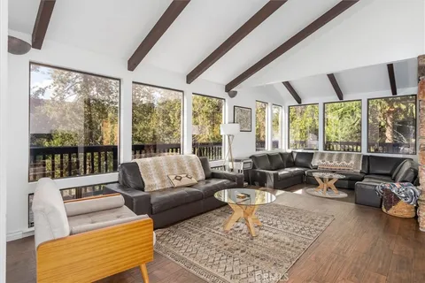 a living room with furniture wooden floor and a flat screen tv