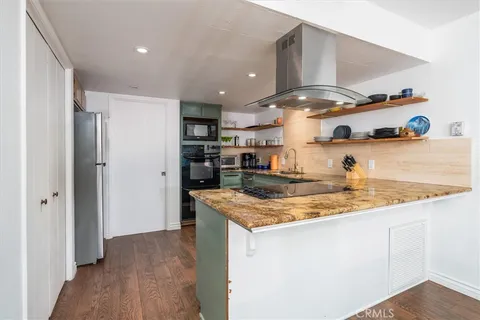 a kitchen with stainless steel appliances granite countertop a sink and wooden cabinets