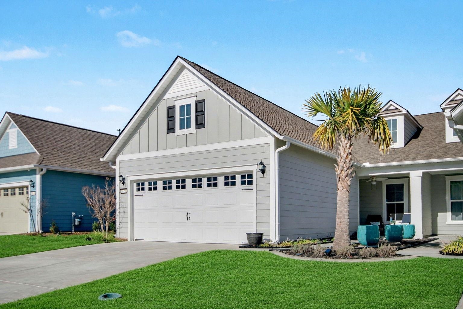 5830 Cremona Drive Myrtle Beach, SC 29577 - Photo 2 of 39 View of front of property with board and batten siding, a garage, a front yard, driveway, and roof with shingles