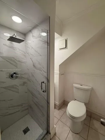 a bathroom with a toilet and a shower