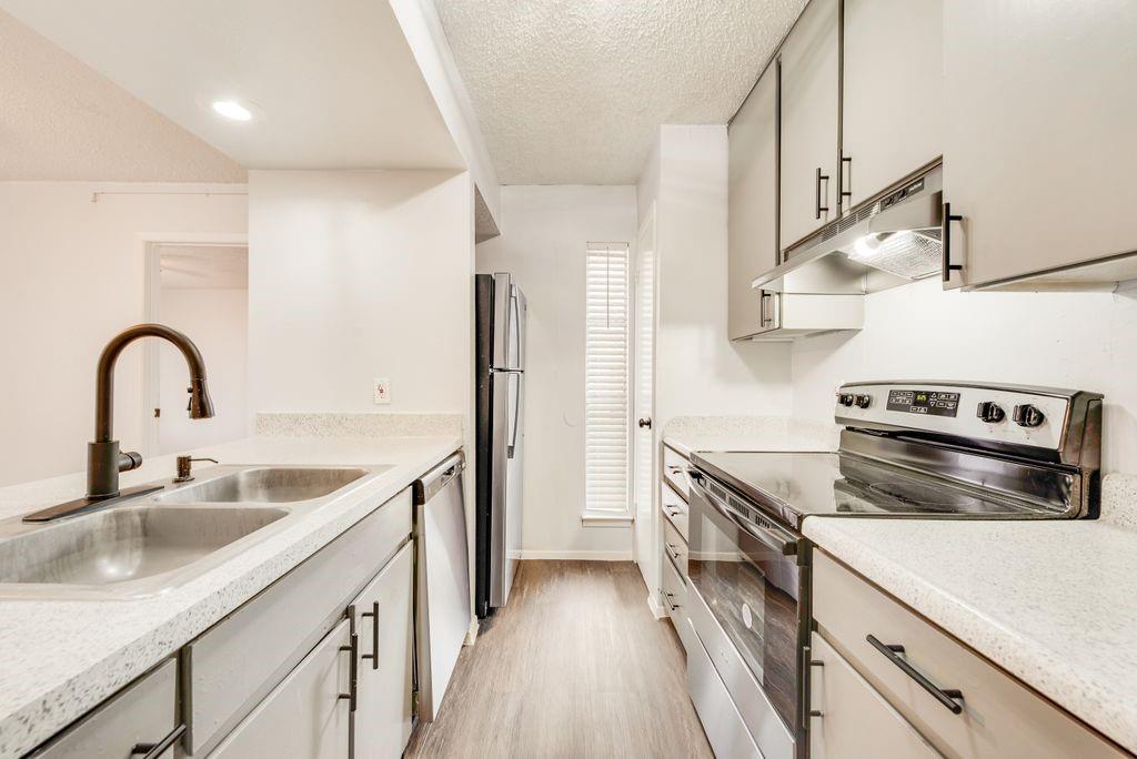 5514 Boca Raton Boulevard, Unit 438 Fort Worth, TX 76112 - Photo 7 of 25 a kitchen with stainless steel appliances granite countertop a sink stove and refrigerator