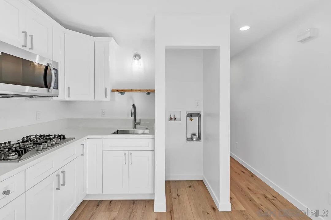 4922 Muir Avenue San Diego, CA 92107 - Photo 21 of 69 a kitchen with white cabinets and sink
