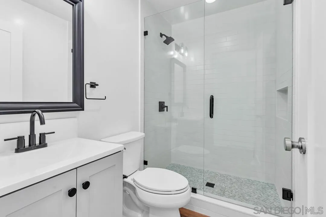 4922 Muir Avenue San Diego, CA 92107 - Photo 29 of 69 a bathroom with a sink a toilet a mirror and shower