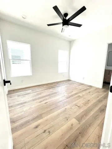 a bedroom with a bed and a potted plant on the dresser