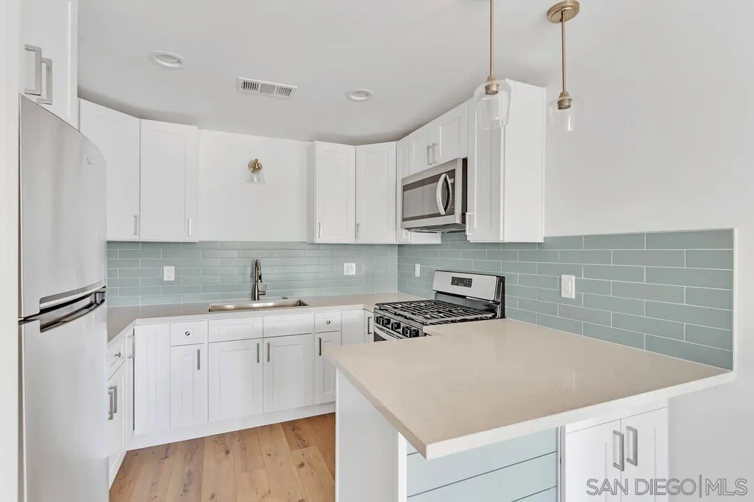 4922 Muir Avenue San Diego, CA 92107 - Photo 5 of 69 a kitchen with a sink a stove and cabinets