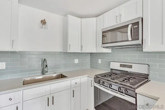 a kitchen with stainless steel appliances a refrigerator sink and cabinets