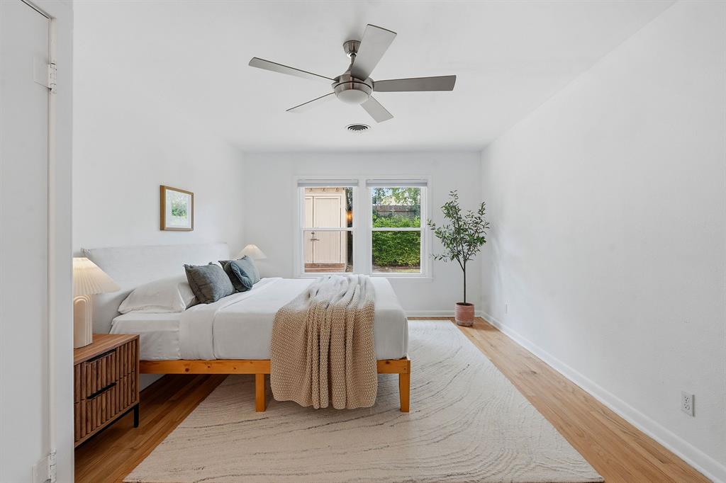 900 Stark Street Austin, TX 78756 - Photo 13 of 25 A well-lit bedroom features hardwood floors and a modern ceiling fan, offering a serene retreat.