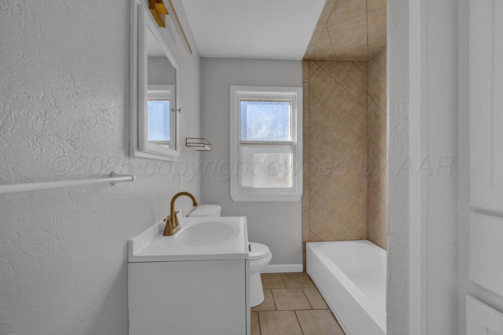 4319 South Lipscomb Street Amarillo, TX 79110 - Photo 11 of 28 a bathroom with a sink a toilet and a mirror