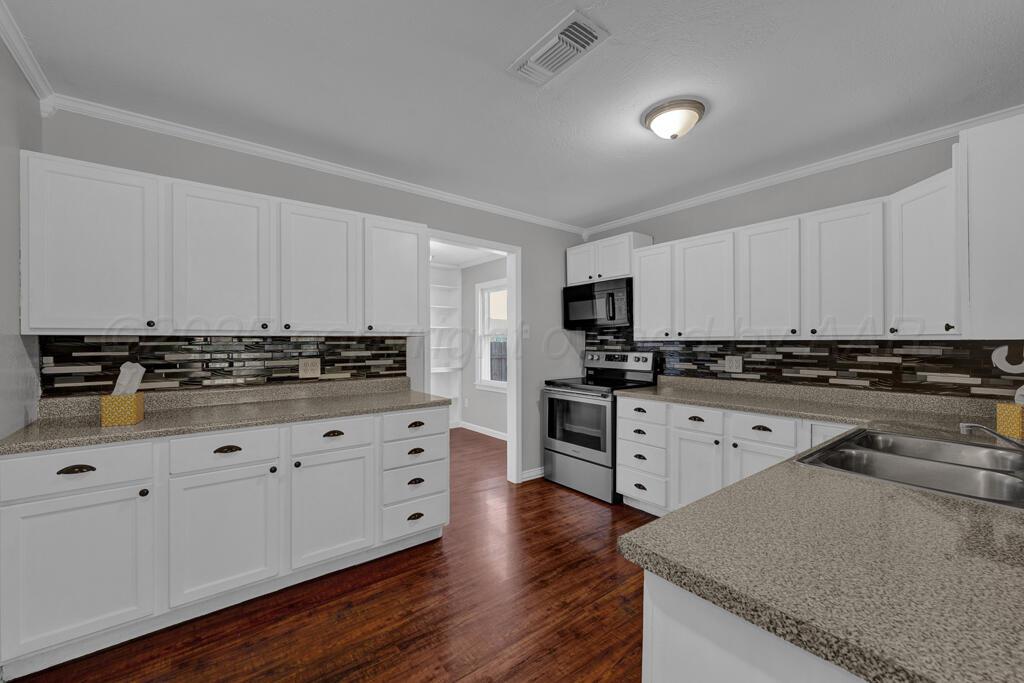 4319 South Lipscomb Street Amarillo, TX 79110 - Photo 18 of 28 a kitchen with granite countertop white cabinets and stainless steel appliances