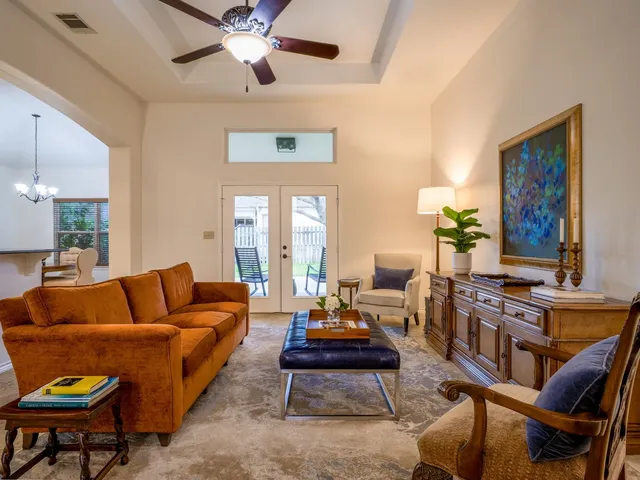 a living room with furniture kitchen view and a chandelier