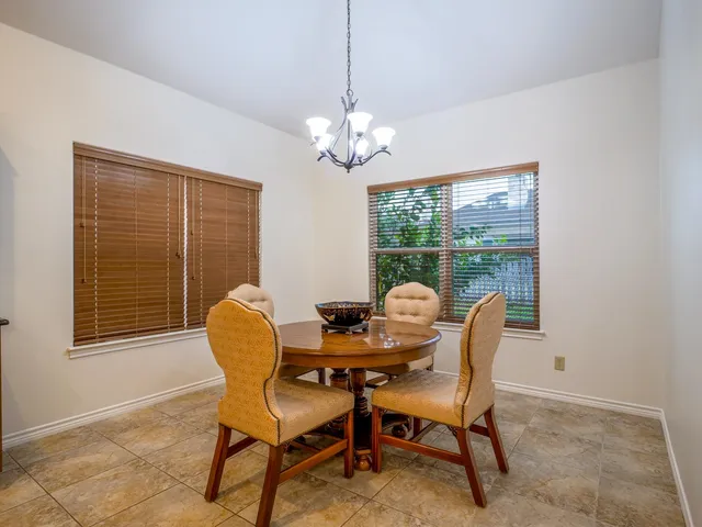 a dining room with furniture a chandelier and window
