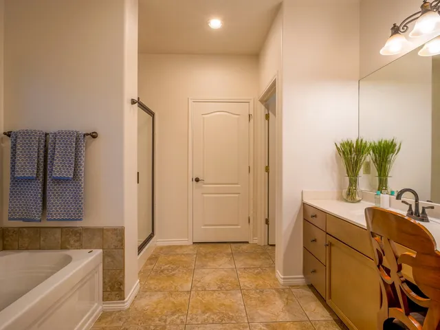 a bathroom with a tub sink and mirror