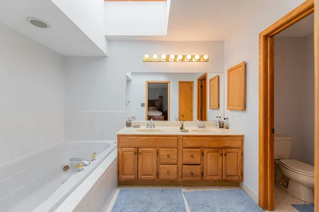a bathroom with a tub a sink and a large mirror