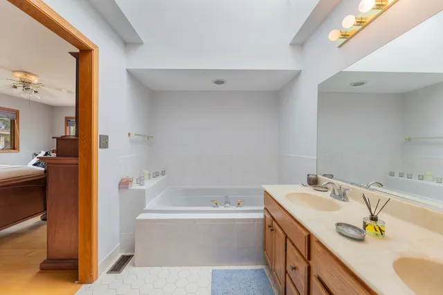a bathroom with a tub sink and mirror
