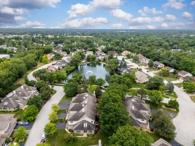 an aerial view of a house with a yard and lake view