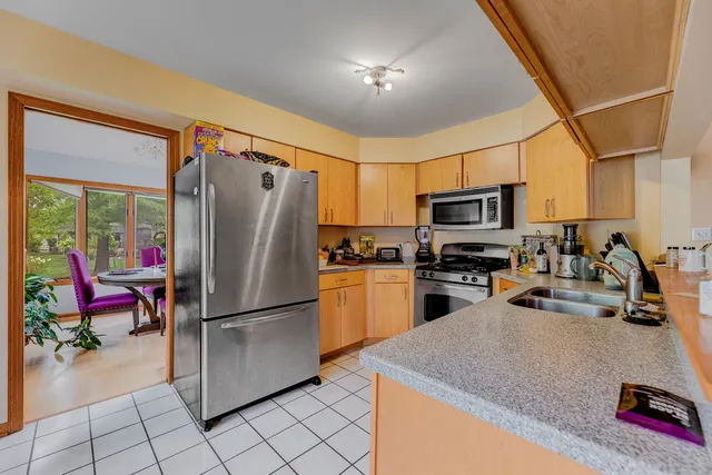 a kitchen with stainless steel appliances granite countertop a refrigerator a stove top oven a sink and dishwasher