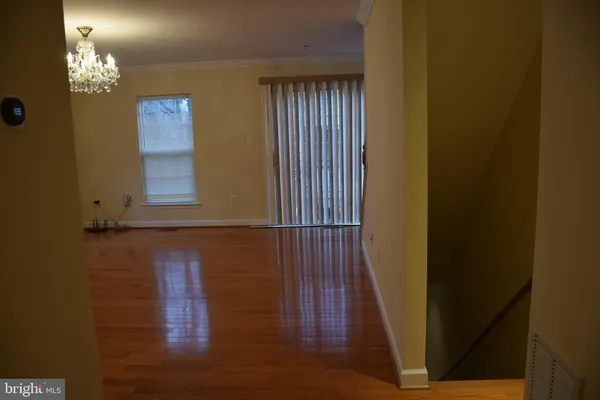a view of livingroom with chandelier and wooden floor