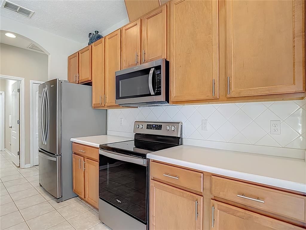 8942 Sandusky Lane New Port Richey, FL 34654 - Photo 20 of 87 a kitchen with granite countertop cabinets stainless steel appliances and a counter space