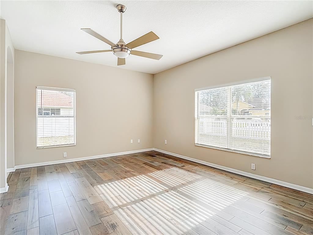 8942 Sandusky Lane New Port Richey, FL 34654 - Photo 26 of 87 an empty room with wooden floor windows and fan